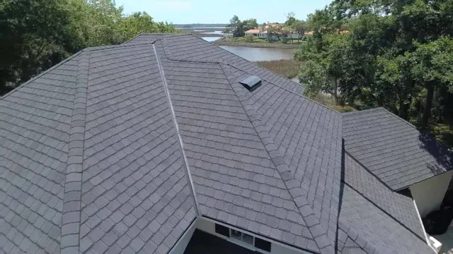 Completed architectural asphalt shingle roof seen from above, with straight hip and ridge lines across several roof planes
