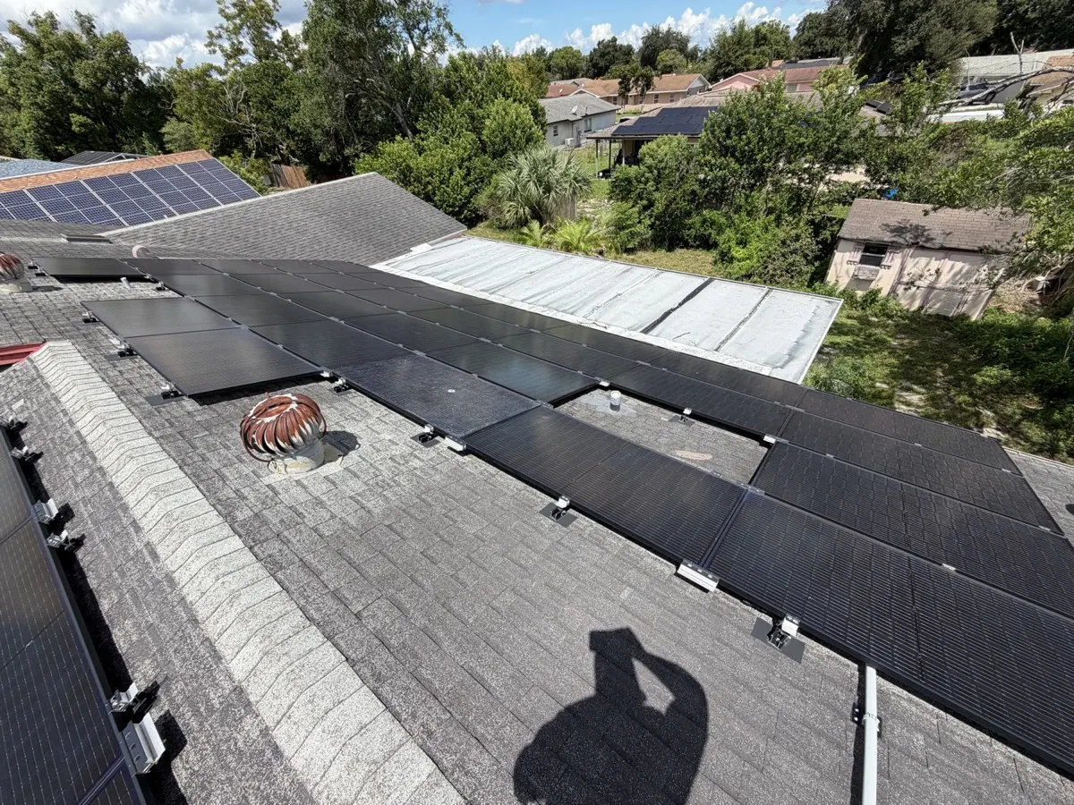 Worn grey shingle roof with a solar array before tear-off, Orlando FL