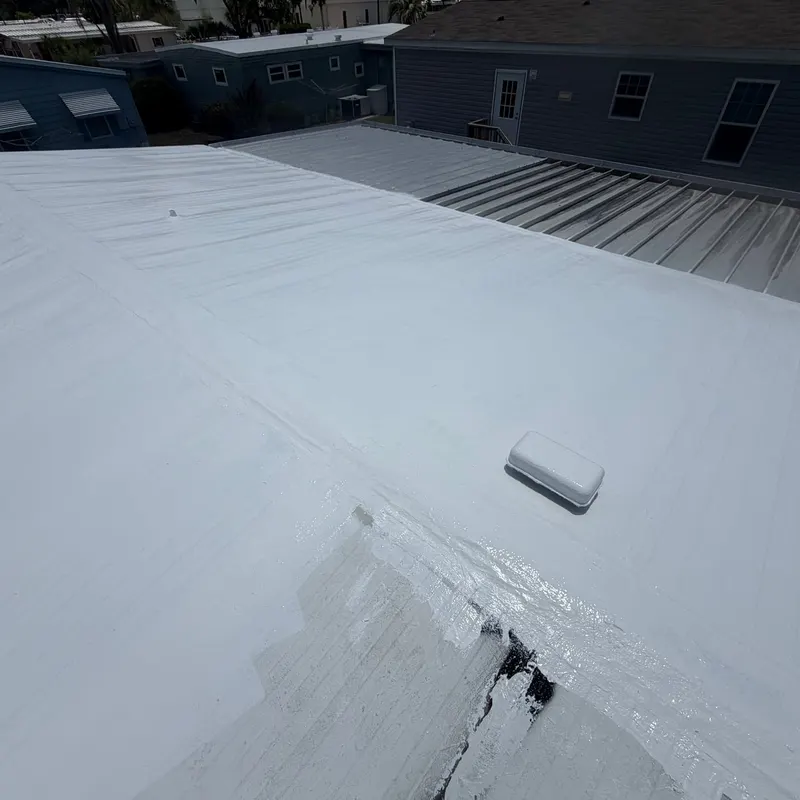 Fresh silicone coating being applied over the roof seams